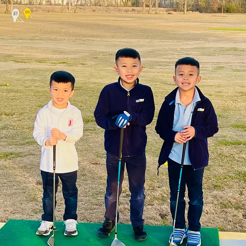 Golfsuites is great for families - 3 kids pose at the golf range
