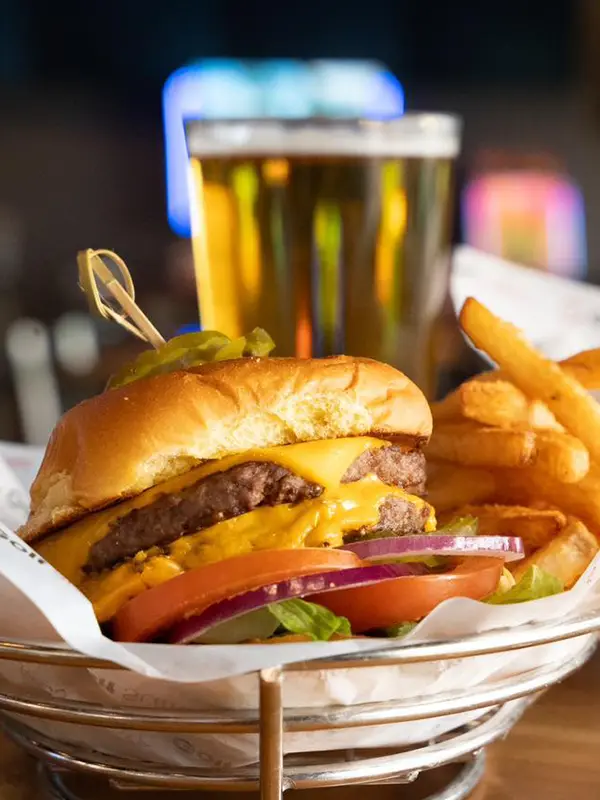 A closeup picture of burgers, fries and a drink at Golfsuites