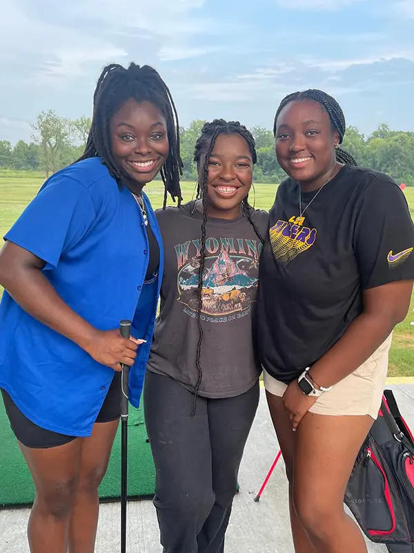 A group of friends taking a selfie while at the driving range at golfsuites baton rouge